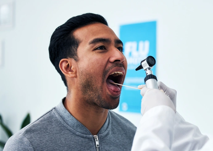 Patient undergoing an oral cancer screening examination at a dental office.
