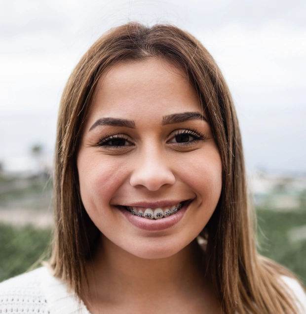 een smiling while wearing traditional metal braces