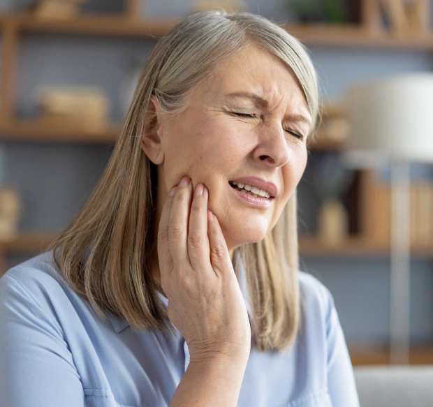 Woman experiencing tooth pain before tooth extraction